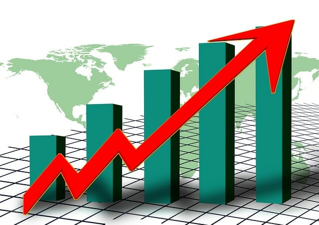 A bar chart against a globe backdrop with a red arrow pointing higher